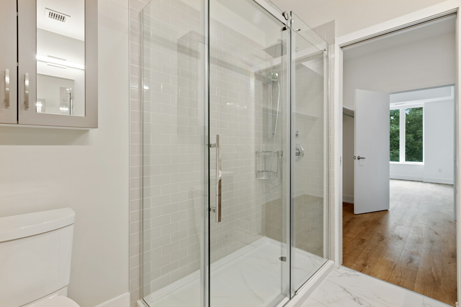 Spacious walk-in shower with frameless glass enclosure and rain showerhead